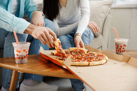 Couple sharing pizza and eatingの写真素材
