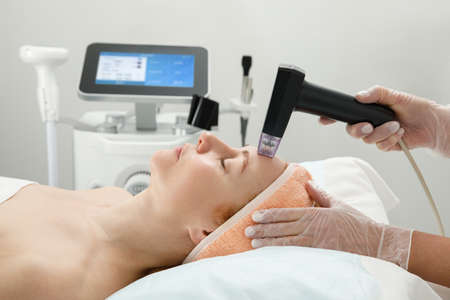 A woman receives laser treatment of the face in a cosmetology clinic, a concept of skin rejuvenation is being developed. laser peelingの写真素材