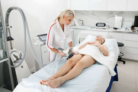 A female cosmetologist performs a rejuvenation procedure in a cosmetology clinic. laser treatment.