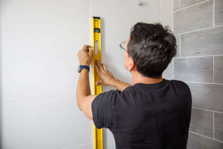 A man is doing repairs in the bathroom.の写真素材