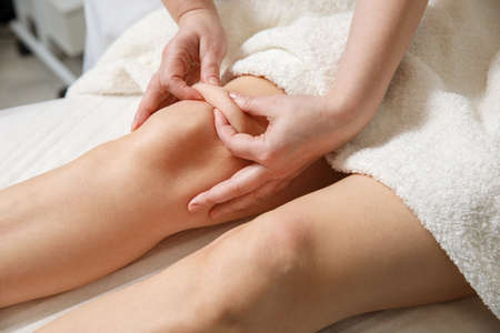 Close up of knee massage procedure in spa salon.の写真素材