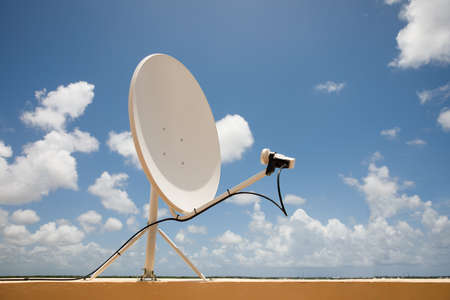 Satellite dish on blue sky background. Parabolic antenna. Reception of the Internet signal from satellites.の写真素材