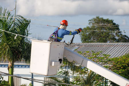 An electrician on a pole is engaged in the installation of electrical wires.