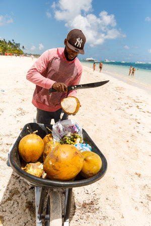 07.24.2022. Dominican Republic, Punta Cana Bavaro province of La Altagracia. Coconut seller on the beach.のeditorial素材
