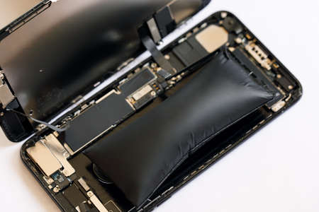 Swollen smartphone battery. Damaged smartphone battery