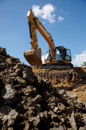 A large construction excavator of yellow color on the construction site in a quarry for quarrying....