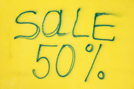 The inscription on the yellow wall with a sale 50
