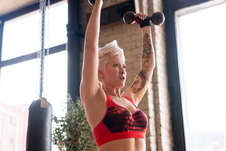 A strong woman trains in the gym. Crossfit training.