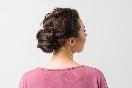 beautiful female hairstyle rear view. The womans hair is arranged in a bun