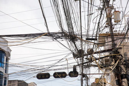 Chaotic overhead power lines and tangled cables for concepts of infrastructure problems, urban...