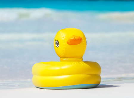 A Bright and Cheerful Yellow Inflatable Duck Pool Float Ready for Fun at the Beachの写真素材