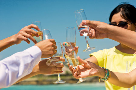 A Joyful and Celebratory Toast by the Gorgeous Beach with Your Wonderful Friends Gathered Togetherの写真素材