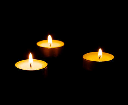  burning candle isolated on black background