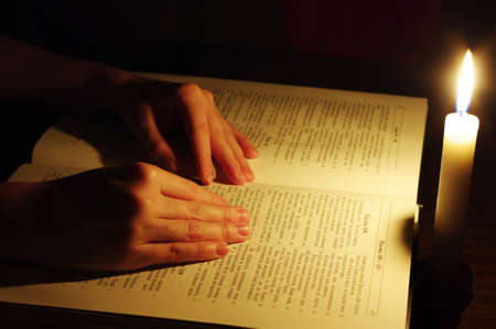 Praying hands on open bible 