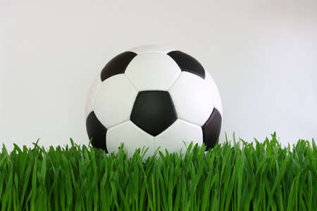 soccer ball on green grass isolated on whiteの写真素材