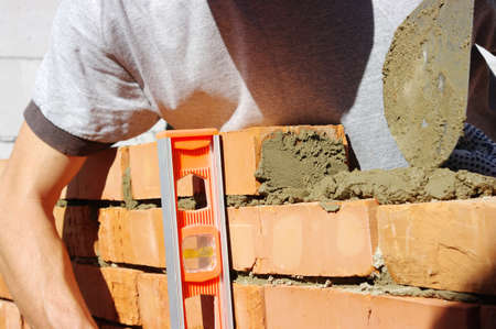 bricklayer laying bricks to make a wall