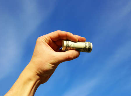 Money in hands on skyの写真素材