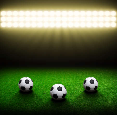 Soccer ball on green stadium, arena in night illuminated bright spotlightsの写真素材
