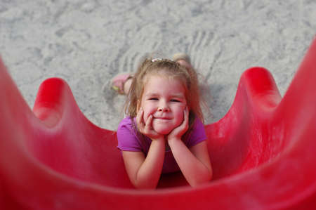 little girl on the playground. Happy smiling child playing on outdoor.