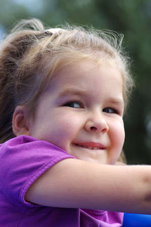 little girl on the playground. Happy smiling child playing on outdoor.