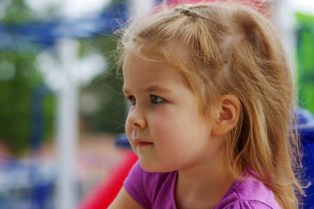 Portrait a little girl on playground. Happy smiling child playing on outdoor.の写真素材