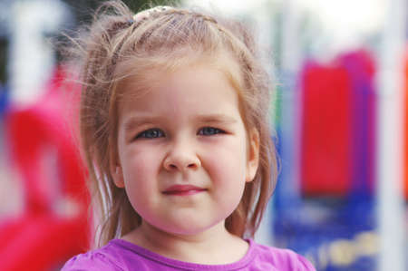 Portrait a little girl on playground. Happy smiling child playing on outdoor.の写真素材
