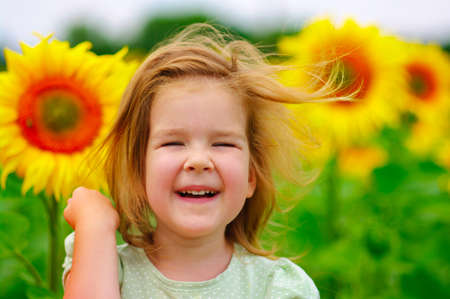 Smiling girl in the sunflowers fieldの写真素材
