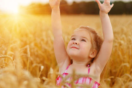 Girl on a wheat field in the sunset.の写真素材