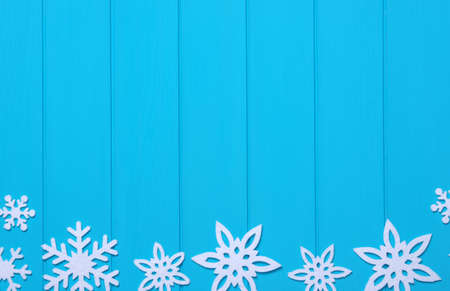 Snowflakes and stars on a blue wooden backgroundの写真素材