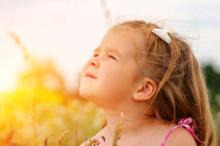 little girl on the meadow in spring dayの写真素材