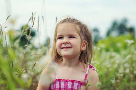 little girl on the meadow in spring dayの写真素材