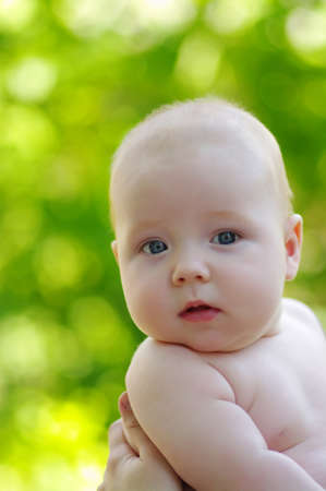 Portrait of baby boy on green bokeh backgroundの写真素材