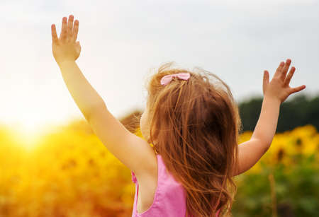 Girl enjoying nature in meadow. Outstretched arms fresh morning air summer field at sunriseの写真素材