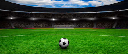 Soccer ball on green stadium, arena in night illuminated bright spotlightsの写真素材