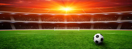 Soccer ball on green stadium, arena in night illuminated bright spotlights