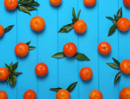 Tangerine with green leaves on wooden background. Top view.の写真素材