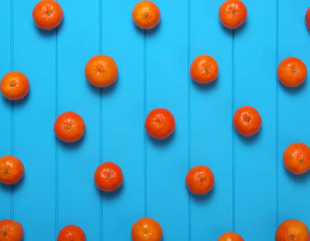 Tangerine with green leaves on wooden background. Top view.の写真素材