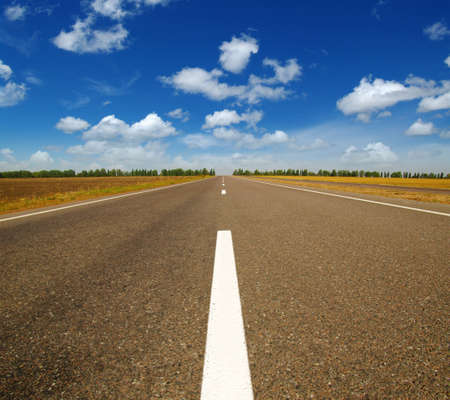 Asphalt car road and clouds on blue sky in summer dayの写真素材