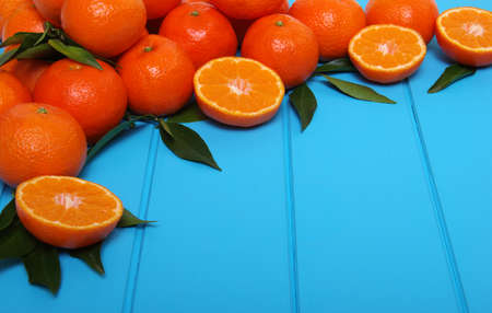 Tangerine with green leaves on wooden background. Top view.の写真素材