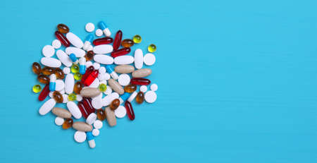 Heap of pills on blue background