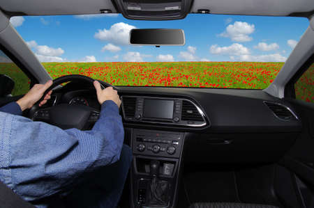The man inside the car is driving along the roadの写真素材