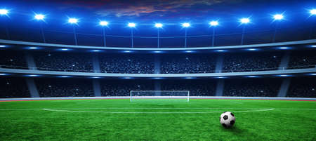 Soccer ball on green stadium, arena in night illuminated bright spotlights