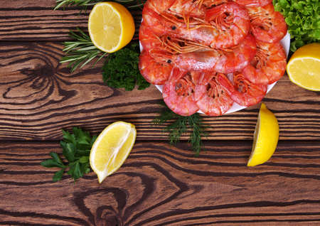 Cooked shrimps with lemon and spices. Seafood served on wooden table. Top view. Close-upの写真素材