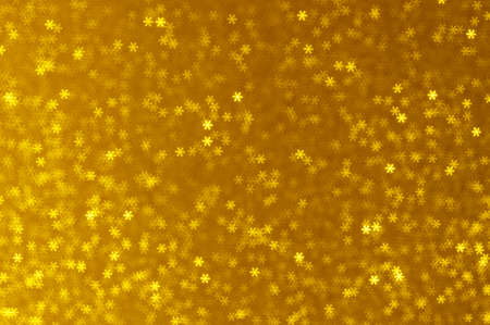 Christmas glowing golden background. Gold Holiday New year abstract glitter defocused lights. Blurred Bokeh.の写真素材