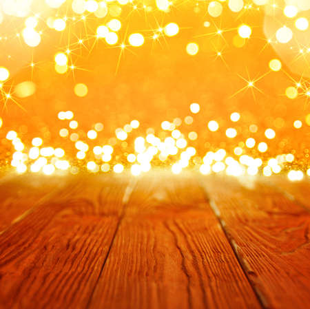 Background with golden bokeh and a empty wooden table with christmas lightの写真素材