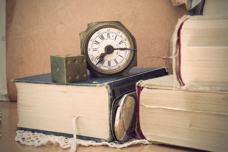 Old clock with brass gambling cube and old booksの写真素材