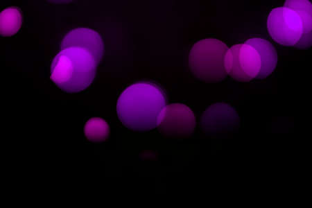 Lilac defocus lights on a black background.の写真素材