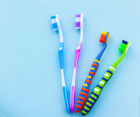Two adults and two childrens toothbrushes on a blue background. Family concept.の写真素材