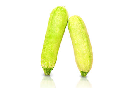 Two zucchini are leaning against each other.の写真素材