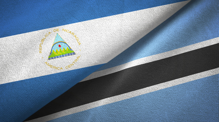 Nicaragua and Botswana two flags textile cloth, fabric textureの写真素材